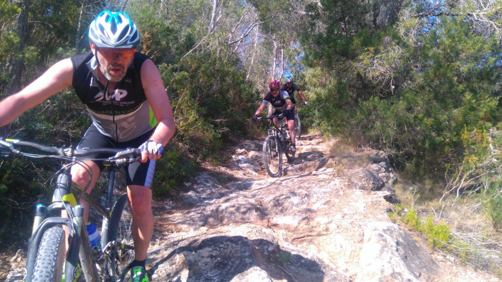 Mountain bikers on a rocky forest trail in Ibiza
