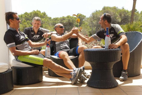 Four cyclists relaxing with a drink on a terrace after a bike tour in Ibiza